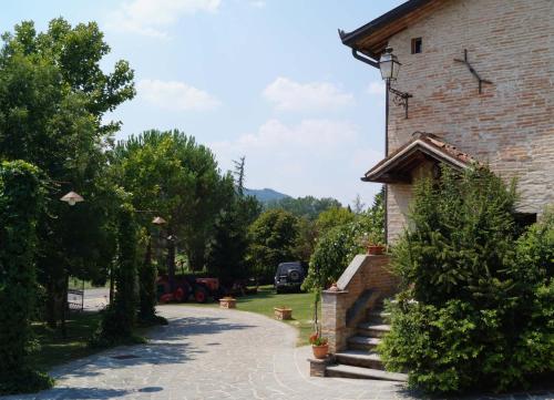a stone walkway leading to a building with trees at Residenza Rurale in Città di Castello