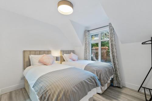 duas camas em um quarto com janela em 6 Rushbrooke Hotel Apartments Cobh County Cork em Cobh