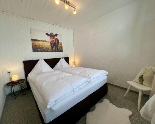 - une chambre dotée d'un lit avec une photo de vache sur le mur dans l'établissement Ferienwohnung 5, à Taxenbach