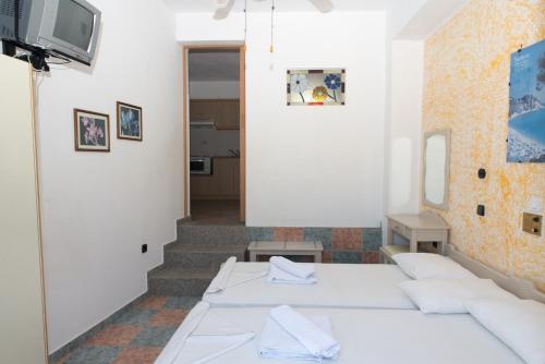 a room with two beds and a tv at Villa Maria in Kokkari
