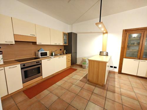 a kitchen with white cabinets and a stove top oven at Lakefront with garden in Oria