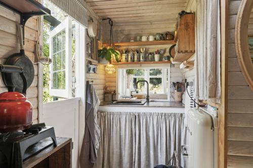a kitchen with a sink and a refrigerator at Wooden House With Wild Garden By Sejerø Bay in Kalundborg