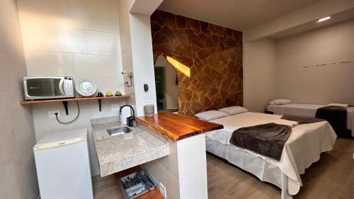 a hotel room with a bed and a sink at Aconchego BH in Belo Horizonte