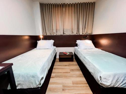 Dos camas en una habitación con ventana. en Smart Malls Mundurucus 1427 batista campos, en Belém