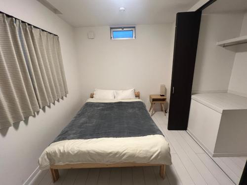 a small bedroom with a bed and a window at 花園之家 in Osaka