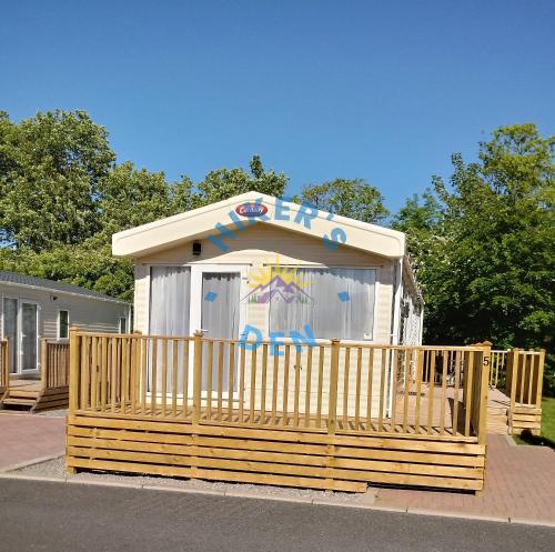 a small play house with a fence in front of it at Hikers Den, Brigham, Cockermouth, Cumbria in Cockermouth