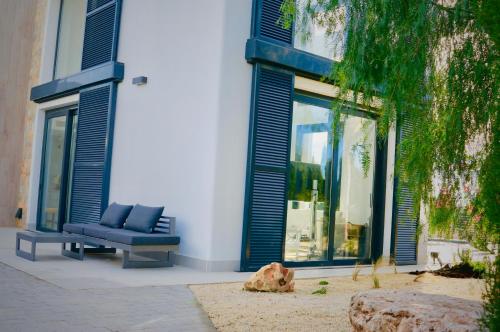 a couch sitting outside of a building with blue shutters at Ferienhaus In Manacor Mit Eigenem Pool in Cala Murada
