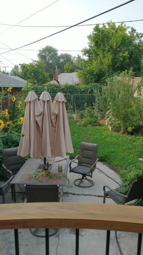 eine Terrasse mit 2 Sonnenschirmen, einem Tisch und Stühlen in der Unterkunft Liberty Park mini-studio in Salt Lake City