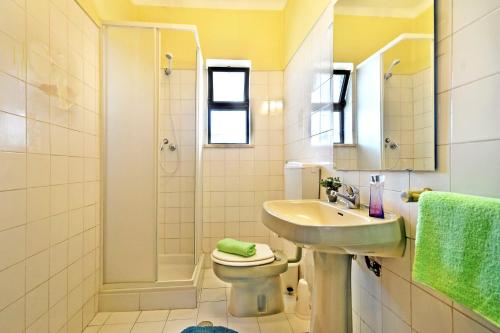 une salle de bain avec un lavabo, des toilettes et une douche dans l'établissement Villa Eira by Villa Plus, à Praia do Carvoeiro