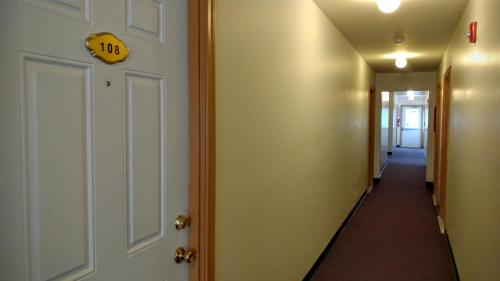a hallway with a door with a sign on it at Stay Inn and Suites in Niagara Falls