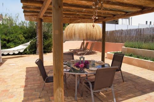 einen Tisch und Stühle unter einer hölzernen Pergola in der Unterkunft Ferienhaus für 4 Personen ca 80 m in Colònia de Sant Pere, Mallorca Nordostküste von Mallorca in Colònia de Sant Pere