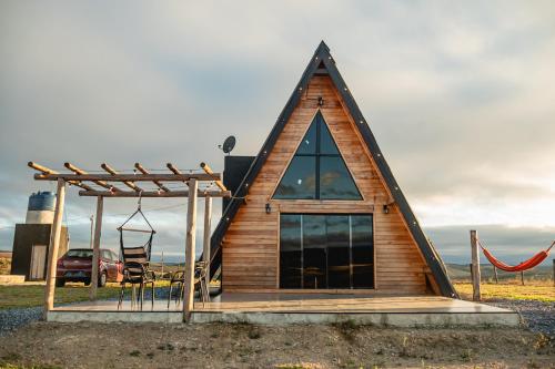 een kleine hut met een schuin dak en een schommel bij Chalé Tia Barbara in Itutinga