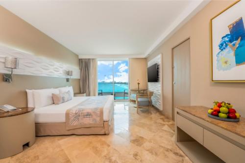 a hotel room with a bed and a view of the ocean at Krystal Grand Cancun All Inclusive in Cancún