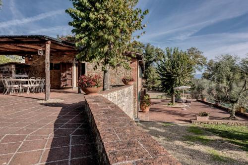 une maison avec un mur de pierre et un patio dans l'établissement Podere Vecciale, à Cavriglia