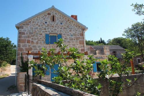 ein Steinhaus mit blauen Fenstern und einem Zaun in der Unterkunft Ferienhaus für 4 Personen ca 65 qm in Seline, Dalmatien Vaganski Vrh in Seline