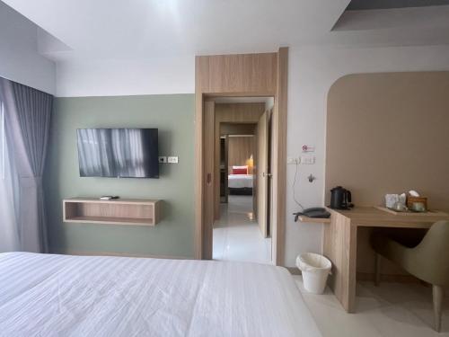 a bedroom with a bed and a television on the wall at Bangkok Mystay Hotel Rangsit in Thanya Buri