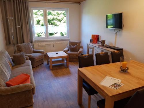 ein Wohnzimmer mit einer Couch und einem Tisch mit Stühlen in der Unterkunft Appartement in Weitersglashütte mit Grill und Garten - b48494 in Eibenstock