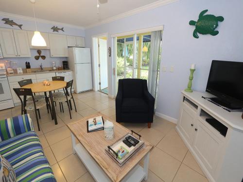a living room with a couch and a table and a kitchen at Silver Sands #232 in Longboat Key