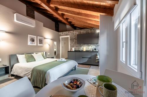 ein Schlafzimmer mit einem Bett und einem Tisch in einem Zimmer in der Unterkunft Alta Via 4 - Free Parking - Sea 20 min - A-C in Altare