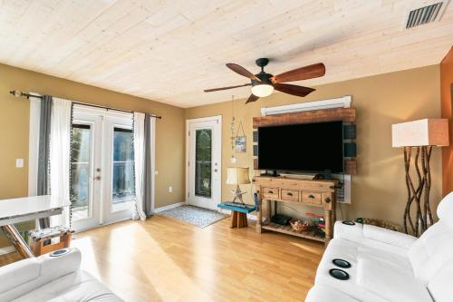 a living room with a ceiling fan and a flat screen tv at Beach Breeze East in Bradenton Beach