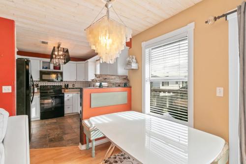 a dining room with a white table and a kitchen at Beach Breeze East in Bradenton Beach