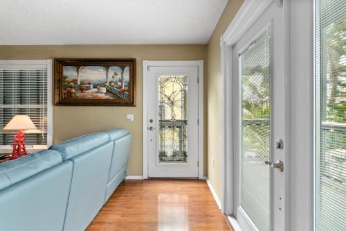 a living room with a blue couch and a window at Beach Breeze West in Bradenton Beach