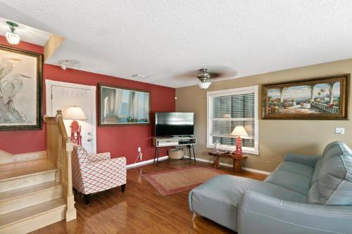 a living room with a couch and a tv at Beach Breeze West in Bradenton Beach