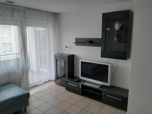 a living room with a flat screen tv on a entertainment center at Chic 2-room apartment very central and quiet in Eislingen