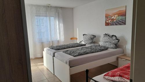 two beds in a small room with a window at Chic 2-room apartment very central and quiet in Eislingen