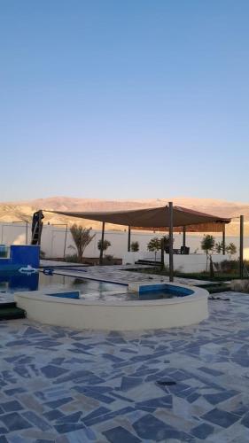 ein weißes Boot in einem Pool mit Sonnendach in der Unterkunft Rest Sea Chaliet & Farm 