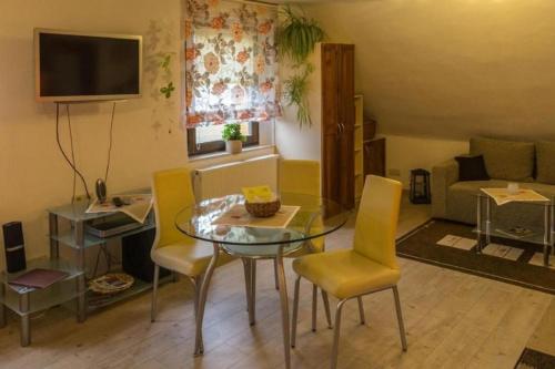 a living room with a glass table and yellow chairs at Wohnung In Niedergurig Mit Grill, Sauna Und Garten in Malschwitz