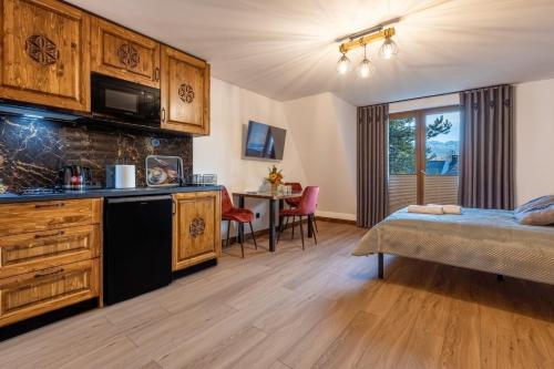 Cette chambre comprend un lit, une cuisine et une table. dans l'établissement Apartamenty 61, à Poronin