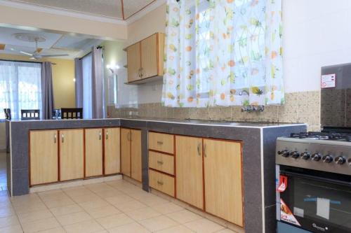 班布里Kerith Springs Family Holiday home Bamburi Msa的空厨房配有木制橱柜和炉灶