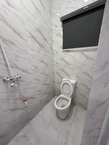 a bathroom with a white toilet in a room at Cool 2Bedroom flat in ogudu, 15mins to the airport in Ogudu