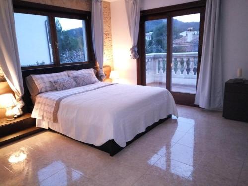 a bedroom with a large bed and large windows at Ferienhaus In Pedruscada Mit Privatem Pool in Cala Ratjada