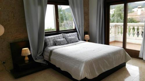 a bedroom with a bed and a large window at Ferienhaus In Pedruscada Mit Privatem Pool in Cala Ratjada