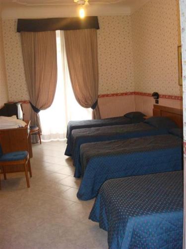 a hotel room with two beds and a desk at Hotel Demetra Capitolina in Rome