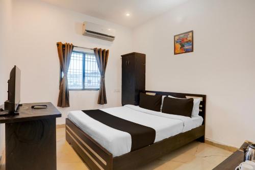 sypialnia z łóżkiem, biurkiem i telewizorem w obiekcie Hotel O The Hunger Byte Resort w mieście Bodh Gaja