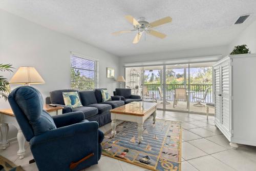 un soggiorno con divani blu e ventilatore a soffitto di Whitney Beach #132 a Whitney Beach