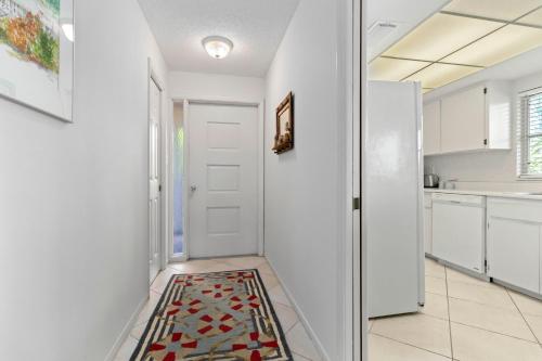 una cucina con una porta bianca e un tappeto sul pavimento di Whitney Beach #132 a Whitney Beach