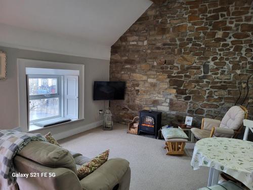 a living room with a stone wall and a fireplace at The Suite on The Diamond in Donegal