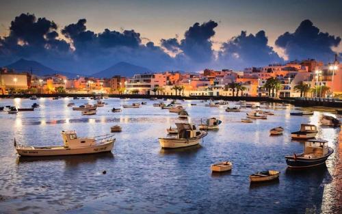 a group of boats sitting in a river with buildings at Ziggy Blues in Arrecife