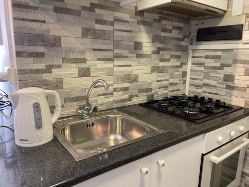 una cocina con fregadero y estufa en Archangelos Studio, en Strovolos