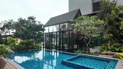 an infinity swimming pool in front of a building at Bangkok Mystay Hotel Rangsit in Thanya Buri