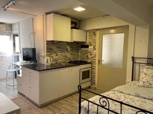 una pequeña cocina con fregadero y una cama en una habitación en Archangelos Studio, en Strovolos