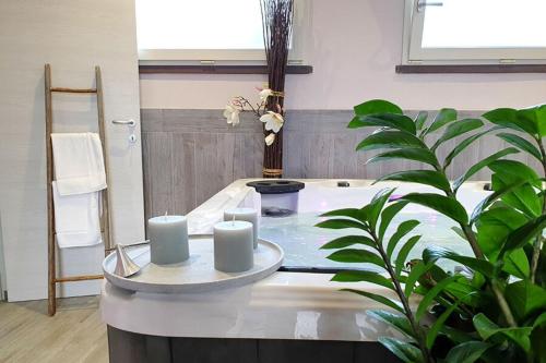 een badkamer met een tafel waarop drie kaarsen staan bij Suite Orchidea Seaside and Pool in La Caduta