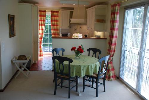 eine Küche mit einem Tisch mit einer Vase mit Blumen darauf in der Unterkunft Ferienwohnung für 3 Personen ca 70 m in Swantow, Ostseeküste Deutschland Rügen in Poseritz