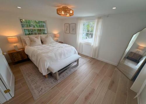 una camera da letto con un grande letto bianco e un lampadario a braccio di Casa Poinsetta a Longbeach