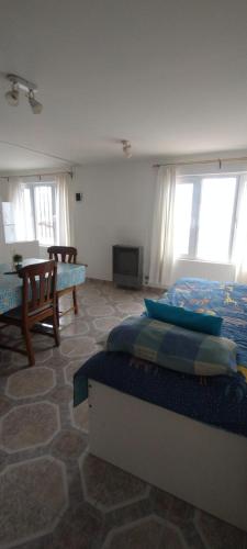 une chambre avec un lit, une table et des fenêtres dans l'établissement Dulce Adelina II Zona Céntrica, à Río Grande