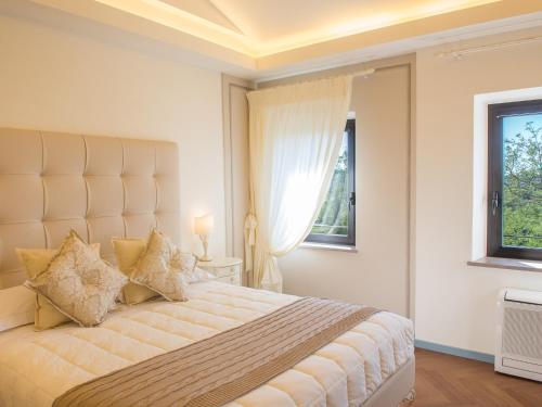 a bedroom with a large bed and two windows at Relais Sassa al Sole in San Miniato